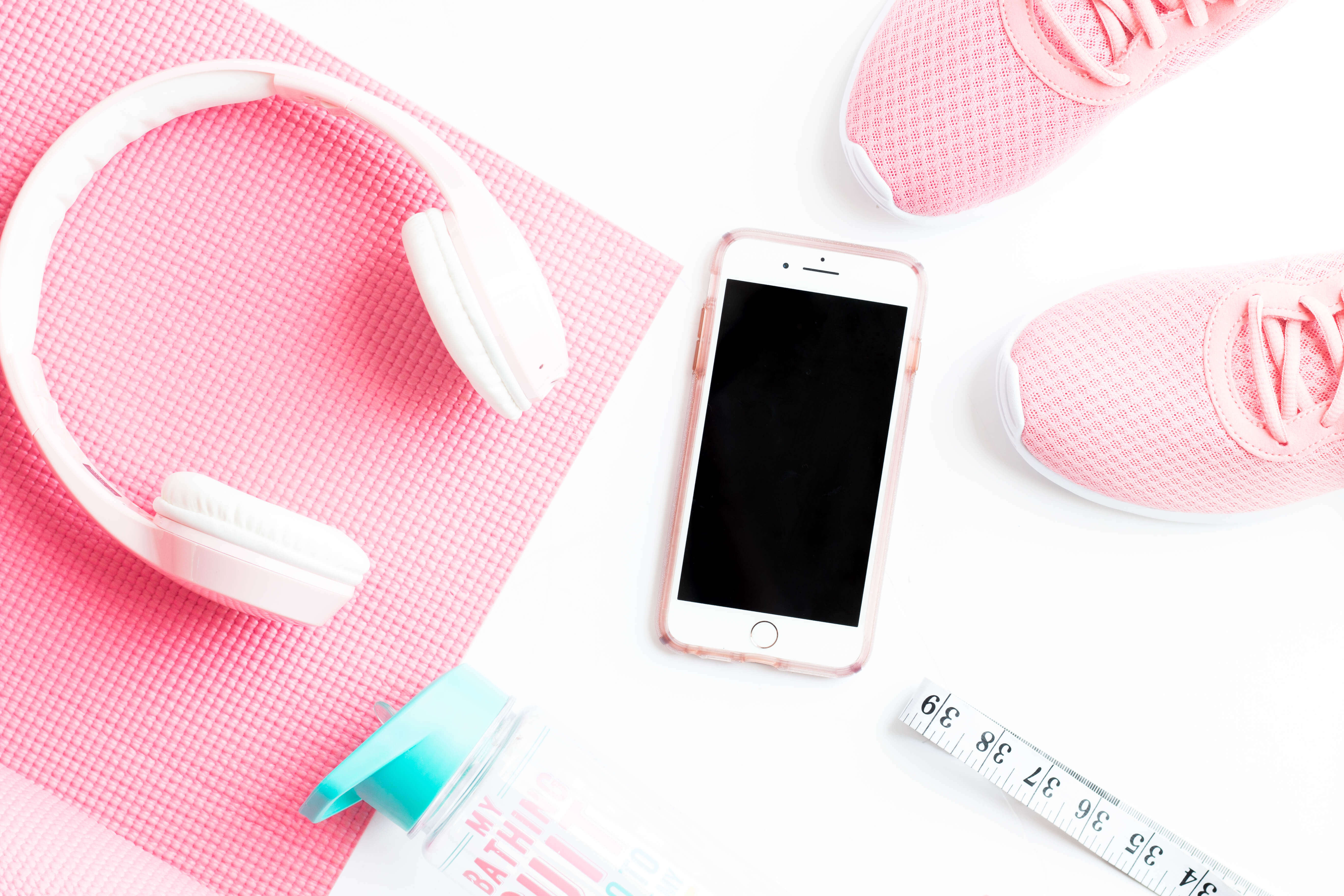 Flat lay with headphones, yoga mat, water bottle, iphone, shoes, measuring tape. Luara from Mom Connection helps help moms lose weight and talking about why moms have a hard time losing weight.
